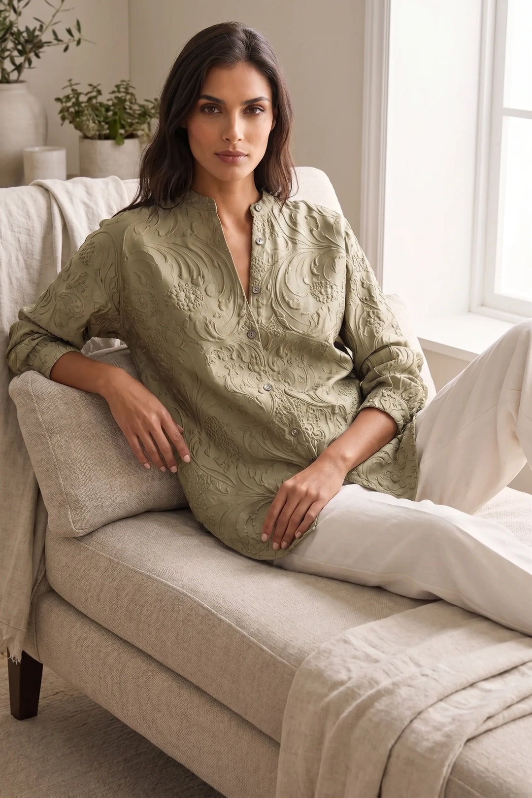 Model wearing green embossed floral blouse in an outdoor lifestyle setting