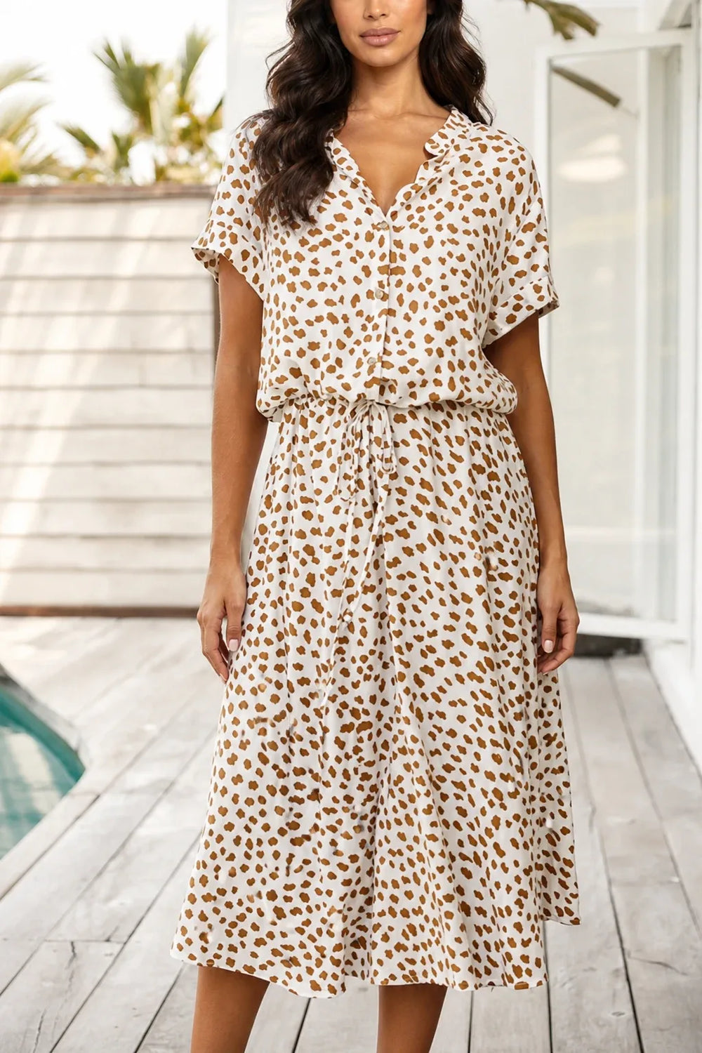 Beige spotted print midi dress on model in contrapposto stance