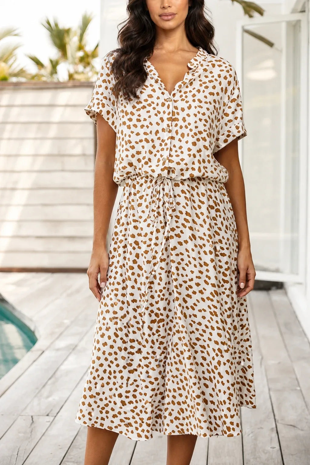 Beige spotted print midi dress on model in contrapposto stance