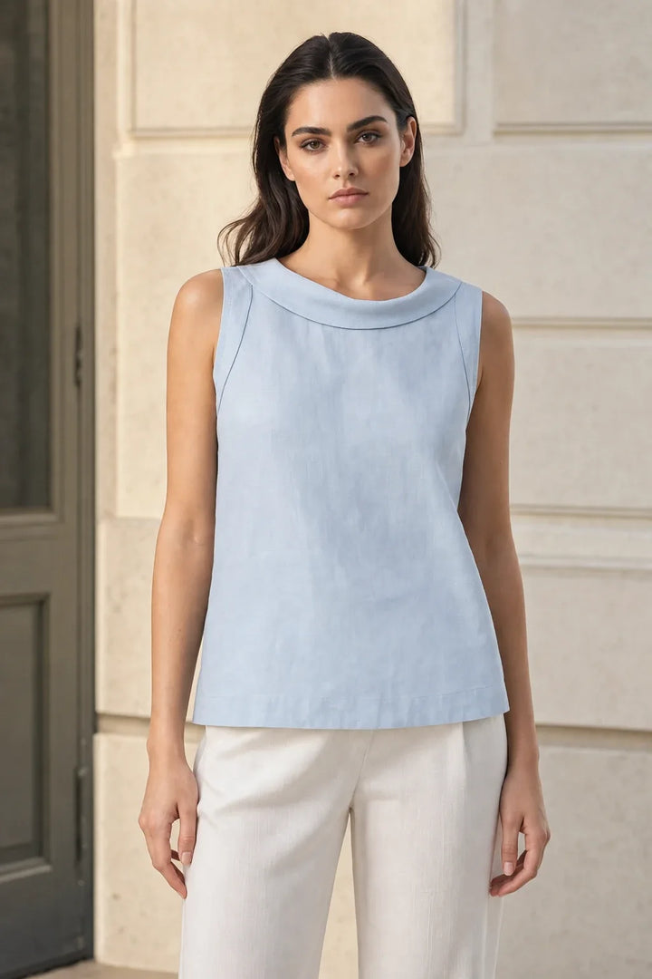 Blue sleeveless blouse with roll collar on model in contrapposto stance