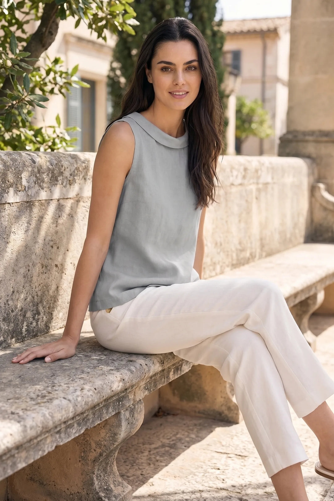 Model styled in grey sleeveless roll collar blouse in casual lifestyle scene