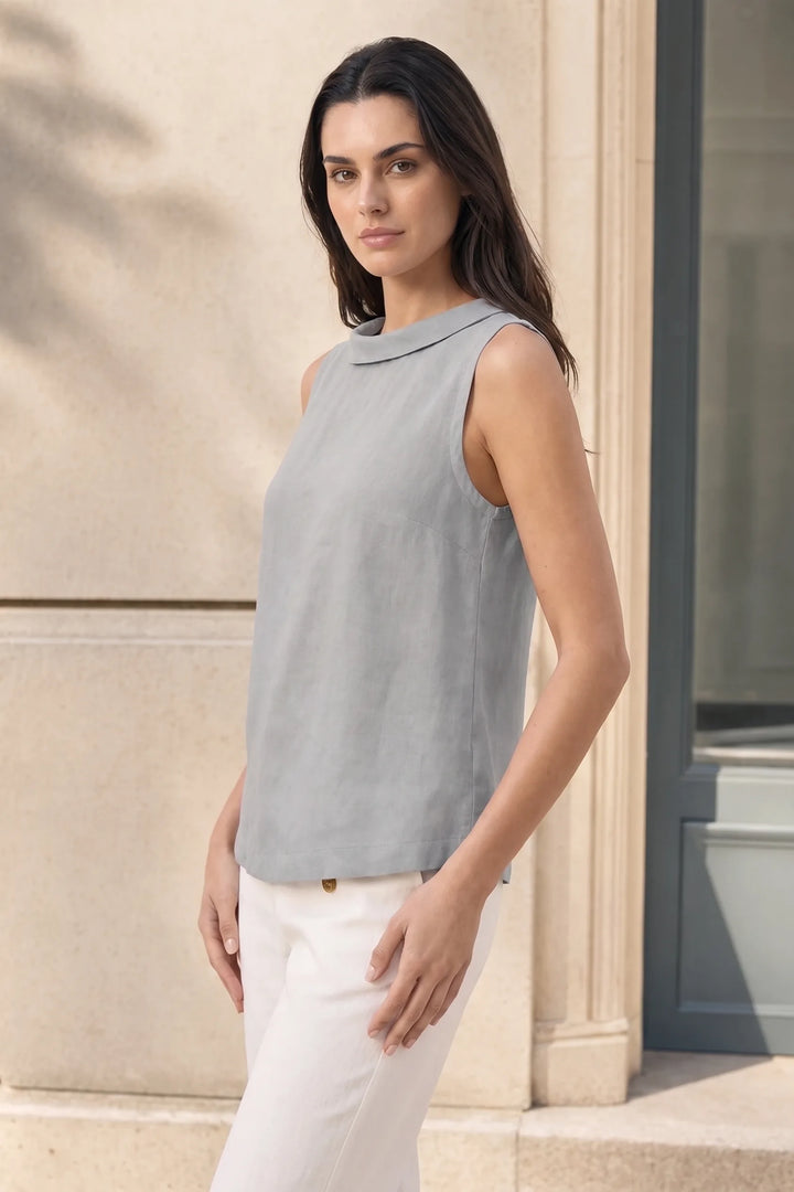Grey sleeveless roll collar blouse on model in three-quarter turn