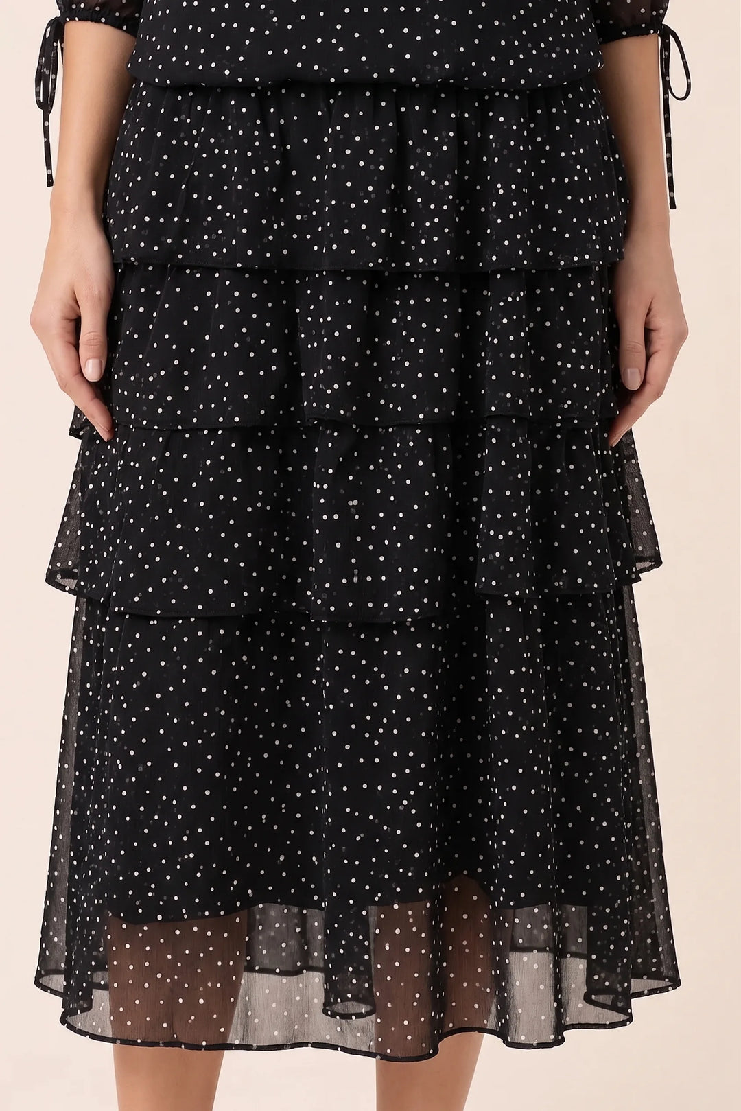 Close-up detail of black tiered polka dot midi dress fabric and tiers