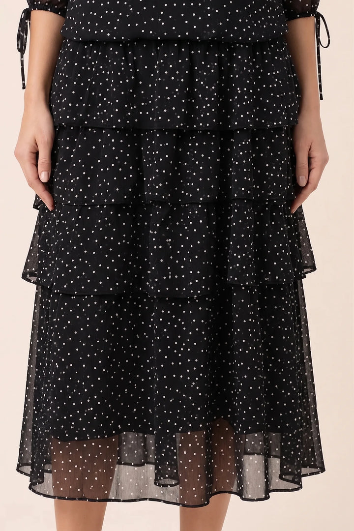Close-up detail of black tiered polka dot midi dress fabric and tiers