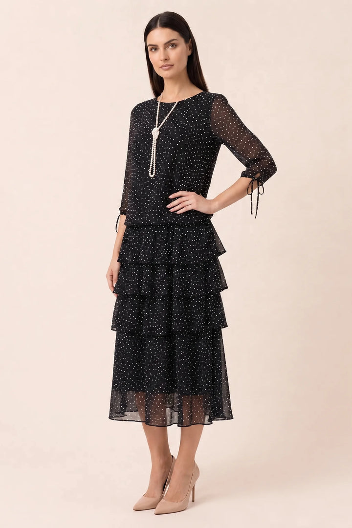 Black tiered polka dot midi dress on model in three-quarter turn