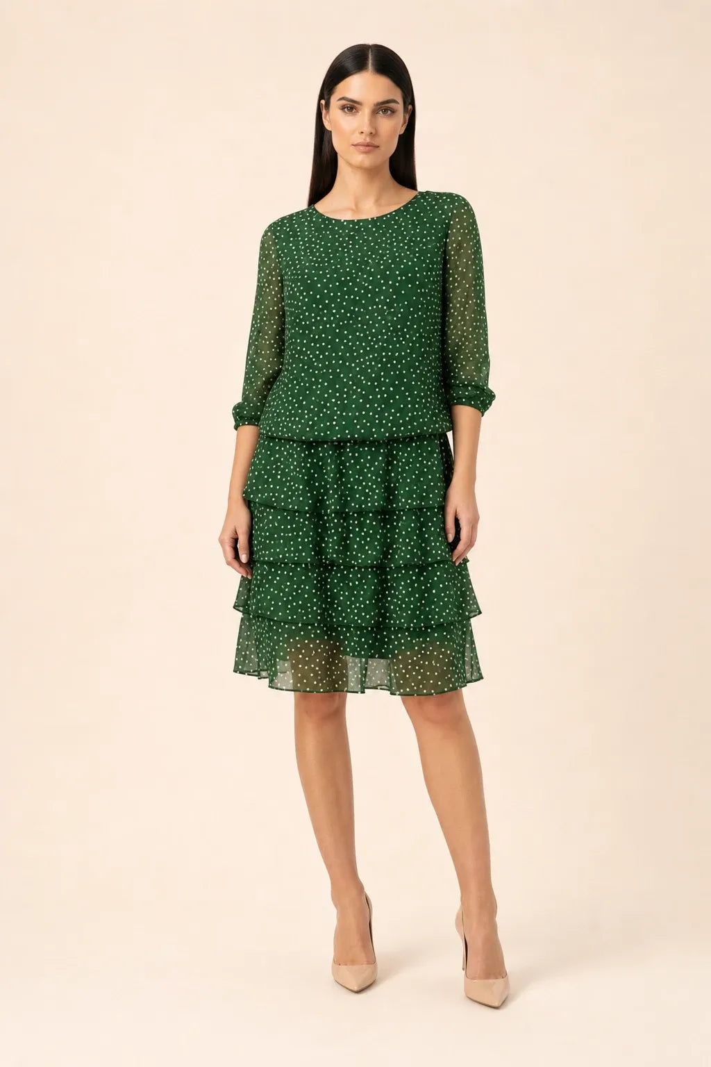 Green tiered polka dot midi dress on model in contrapposto stance