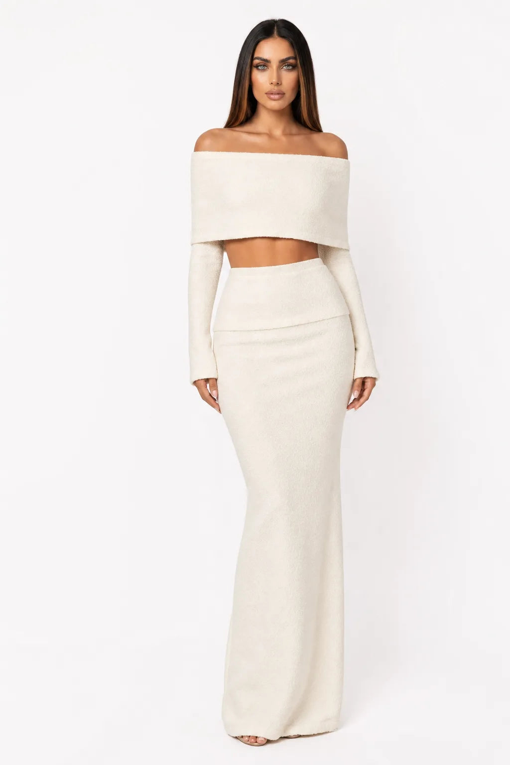 White off-shoulder knit crop top and matching skirt set on model in contrapposto stance