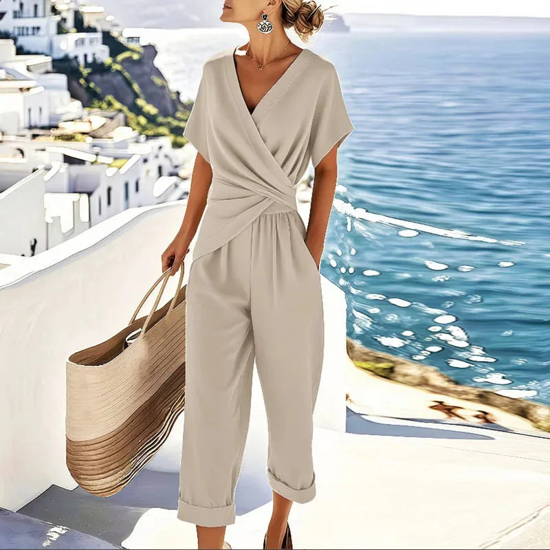 Woman wearing a sleeveless apricot twisted wrap jumpsuit, facing forward